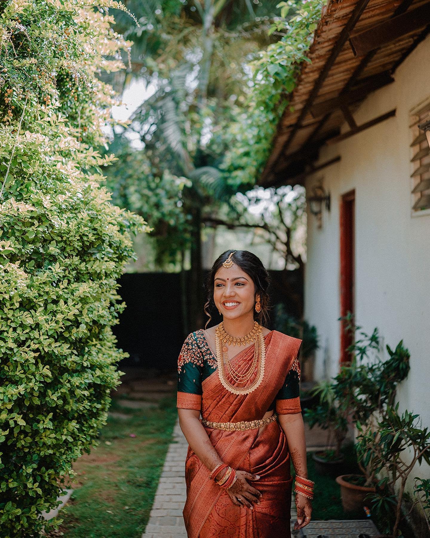 A bride smiling in a lush garden
