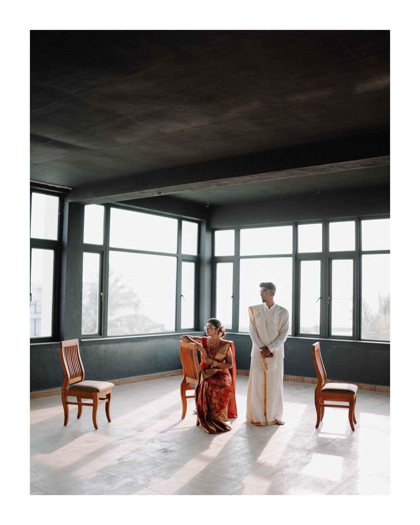 A wedding couple posed in a sunlit room